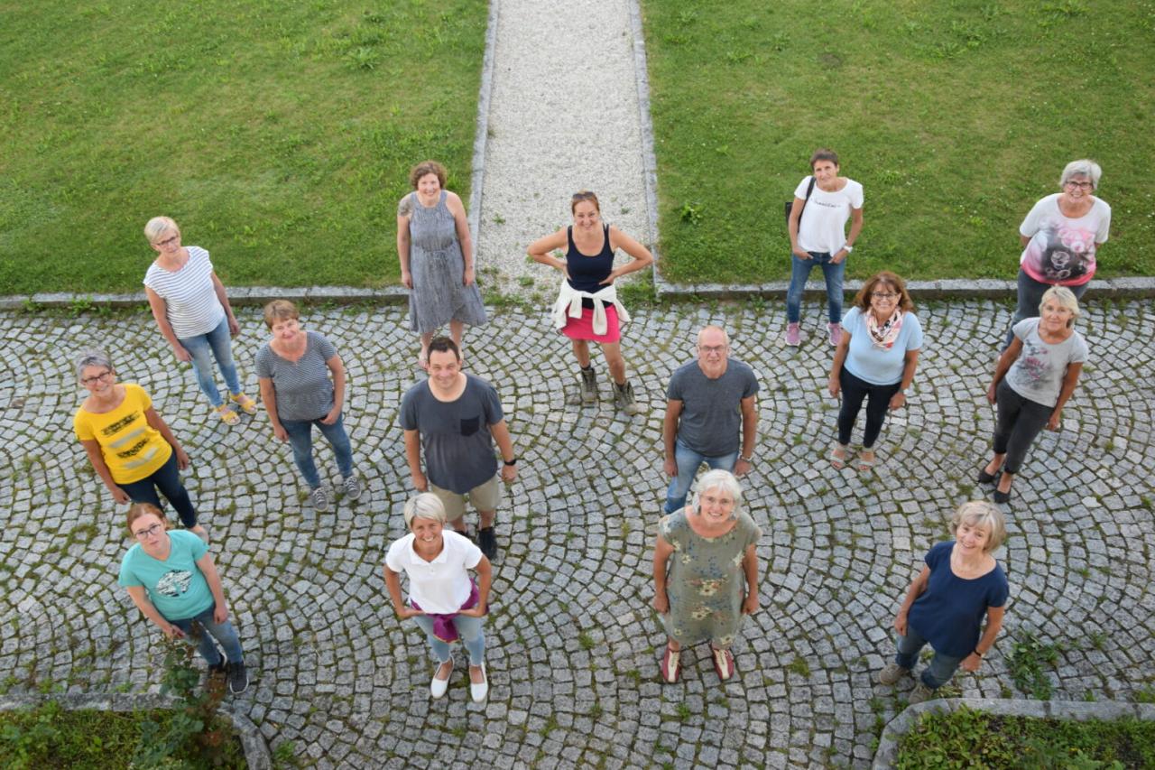 Teammitglieder stehen mit etwas Abstand voneinader. Von oben wurde auf sie runterfotografiert.